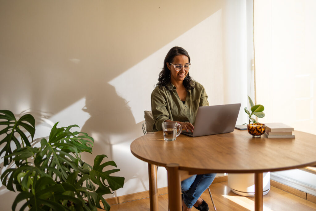 Women sitting at kitchen table with laptop